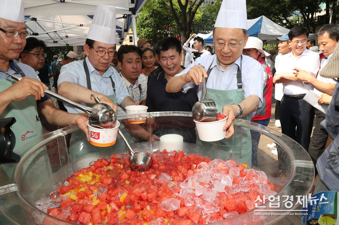 황창규 회장과 박원순 시장이 동자동 쪽방촌 주민들에게 수박 화채를 나누어 주고 있다.