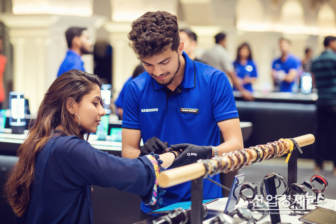 삼성전자 인도 직원이 고객에게 모바일 제품을 시연하고 있다.