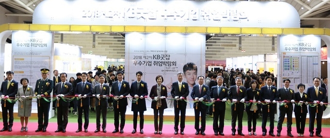 21일, 『2018 제2차 KB굿잡 우수기업 취업박람회』개막식에 참석한 내외빈들이 테이프 커팅식을 하고 있다. (왼쪽 2번째)송미영 국가과학기술연구회 본부장, (왼쪽 4번째)김광우 국가보훈처 제대군인국 국장, (왼쪽 5번째)이재강 국방전직교육원 원장, (왼쪽 6번째)이남우 국방부 인사복지실장, (왼쪽 7번째)도성훈 인천광역시 교육청 교육감, (왼쪽 8번째)이승기 KB홍보모델, (왼쪽 9번째)유은혜 부총리 겸 교육부장관, (오른쪽 9번째)허인 KB국민은행장. 사진 = 국민은행