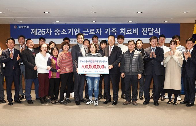 14일 을지로 기업은행 본점에서 김도진 은행장(앞줄 오른쪽 다섯 번 째)과 이정재 홍보모델(앞줄 왼쪽 여섯 번째), 중소기업 근로자 가족들이 치료비 전달식을 마치고 기념촬영을 하고 있다. 사진 = 기업은행