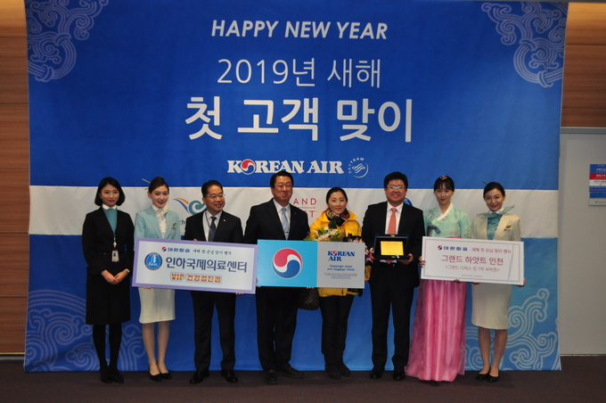 새해 첫 고객 맞이 행사’에 참가한 대한항공 임직원 등 관계자들이 대한항공 새해 첫 고객 중국인 위페이씨(오른쪽에서 네번째)와 함께 기념 사진을 찍고 있다. 사진 = 대한항공