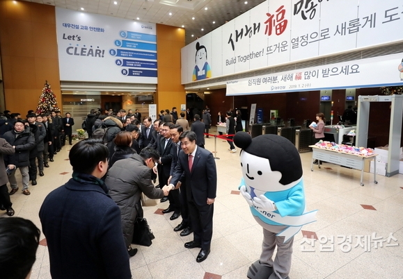 대우건설 김형 사장이 새해 첫 출근하는 임직원들을 맞이해 일일이 악수를 나누며 떡이 담긴 복주머니를 전달하는 것으로 시무식을 대신하고 있다. 사진=대우건설