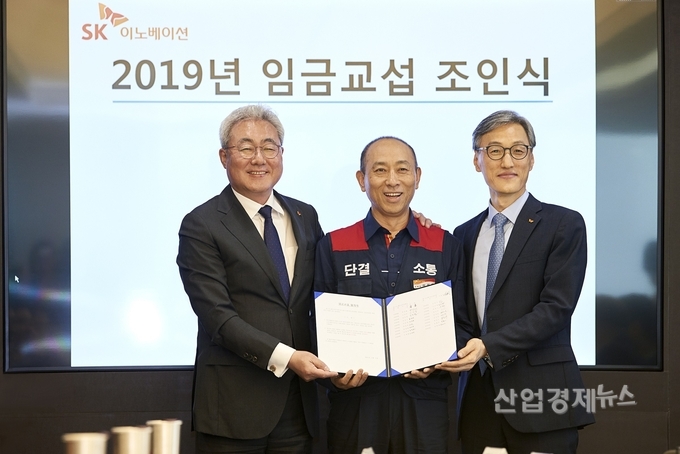 2019년 임금협상 조인식에 참석한 (왼쪽부터) SK이노베이션 김준 총괄사장, 이정묵 노조위원장, SK에너지 조경목 사장이 30분만에 합의된 합의안을 들고 기념사진을 촬영하고 있다. 사진=SK이노베이션 제공