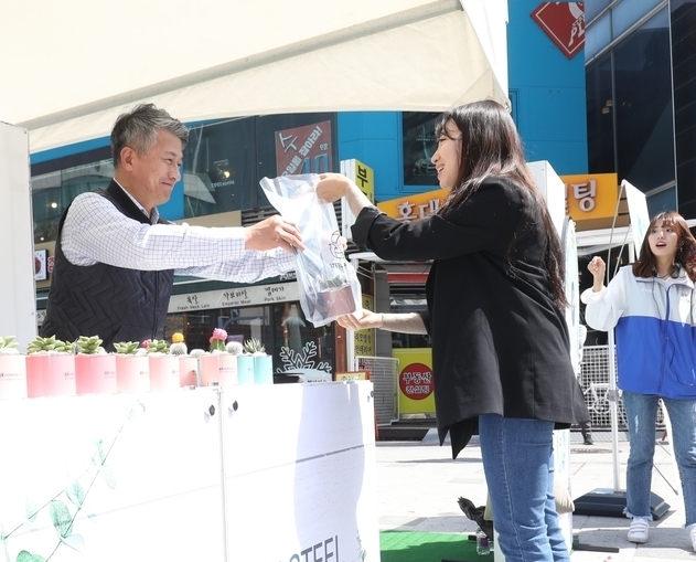 동국제강 장세욱 부회장이 시민들에게 철제 화분을 나눠주고 있다. 사진=동국제강