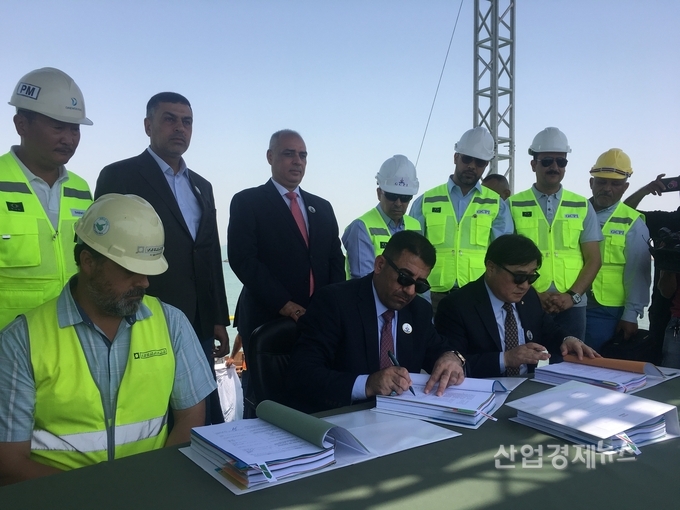 이라크 교통부 알 말리키 장관(왼쪽)과 대우건설 박찬용 상무(오른쪽)가 4월 30일 이라크 알 포(Al Faw) 서방파제현장 준공식에서 컨테이너터미널 공사 계약서에 사인을 하고 있다. (대우건설 제공)