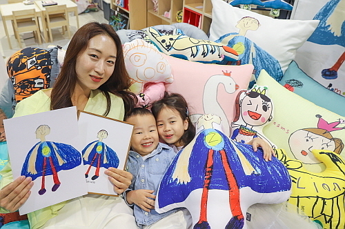 4일 오전 현대백화점 중동점 6층 '아토 드로잉' 팝업스토어에서 어린이 모델이 직접 그린 그림과 제작된 상품을 직원과 함께 선보이고 있다..<사진=현대백화점 제공>