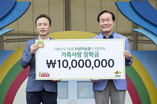 지난 6월 열린 10주년 의성마늘햄 가족캠프에서 이경석 롯데푸드 마케팅부문장(왼쪽)이 김주수 의성군수(오른쪽)에게 장학금 전달 모습...<사진=롯데푸드 제공>