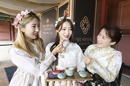 ‘왕후, 비밀의 공간’ 전시를 찾은 방문객들이 궁중미용을 체험해보고 있는 모습...사진=LG생활건강 제공