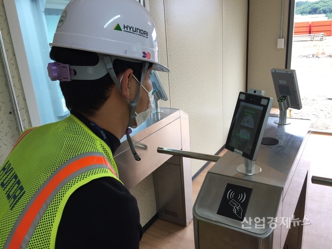 현대건설 작업자가 안면인식 시스템을 통해 건강상태를 확인하고 있다. 사진=현대건설