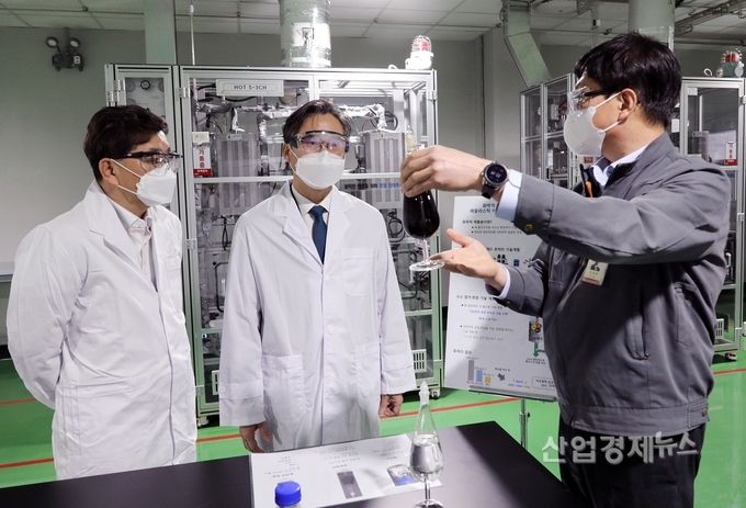 산업통상자원부 박진규 차관(가운데)이 9일 SK이노베이션 환경과학기술원 내 국내 최초 폐플라스틱 열분해유 연구개발 현장을 방문해, 열분해유 시제품을 살펴보고 있다. /SK종합화학 나경수 사장(왼쪽), SK이노베이션 이성준 환경과학기술원장(오른쪽). 사진=SK이노베이션