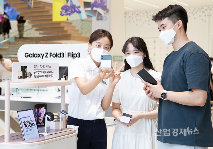 삼성 디지털프라자 홍대점에서 갤럭시 팬큐레이터에게 '갤럭시 Z 폴드3', '갤럭시 Z 플립3', '갤럭시 워치4' 시리즈를 3일 간 자유롭게 체험해볼 수 있는 '갤럭시 To Go 서비스'를 안내받고 있는 모습. 사진=삼성전자