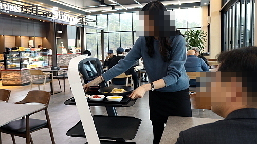 고객이 서빙된 음식을 로봇에서 꺼내는 모습..CJ프레시웨이 제공