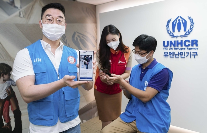 SKT와 유엔난민기구 직원들이 SKT RCS비즈웹을 통해 발송한 메시지를 소개하는 모습. 사진=SK텔레콤