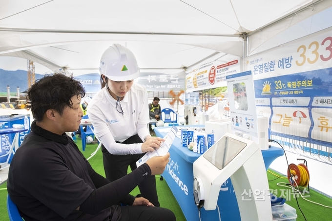 혹서기 특별 현장점검 및 폭염 안전 공동 캠페인에서 현장 근로자(사진 왼쪽)가 스트레스 진단을 받고 있다. 사진=현대건설