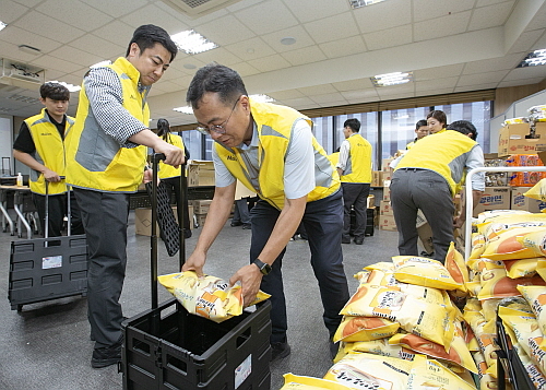 동서식품 임직원들이 음식과 생필품을 담은 효도 카트를 제작하고 있는 모습...<사진=동서식품 제공>