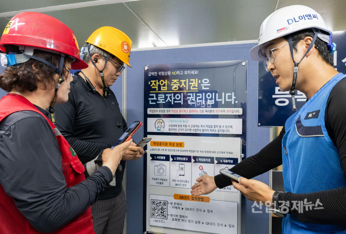 DL이앤씨 현장 안전관리자(우측 첫번째)가 현장 근로자들에게 안전신문고 접속 및 작업중지권 사용법에 대해 설명하고 있다. 사진=DL이앤씨