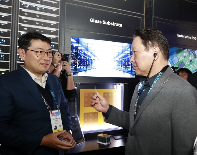 최태원 SK 회장이 지난 1월 미국 라스베이거스에서 열린 ‘CES 2025’ 행사장에 마련된 SK 전시관에서 유리기판을 살펴보고 있다...<사진=SK그룹 제공>