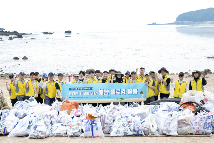동서식품이 지난 19일 인천 무의도 해안가에서 플로깅 직원 봉사활동을 진행했다. 봉사활동에 참여한 동서식품 직원들이 기념촬영을 하고 있다.